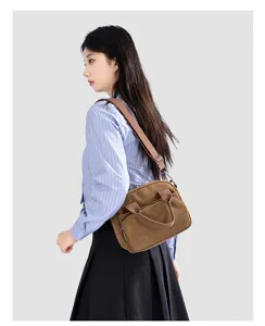 Casual brown canvas crossbody bag for women, featuring dual handles and adjustable strap.