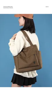 Detail view of the brown canvas tote bag featuring front zipper pocket and large capacity.