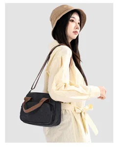 Detail view of casual canvas crossbody bag worn by model, showing color-block design.