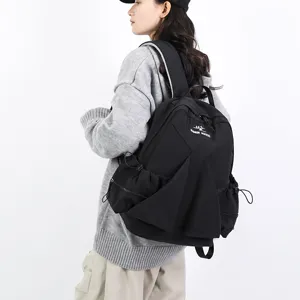Black pleated nylon canvas backpack worn by model, casual large capacity school bag.