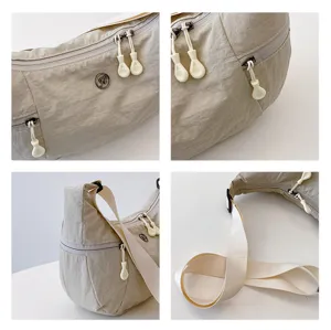 Nylon shoulder bag close-up detail showcasing smooth zippers, pull tabs, and durable strap.