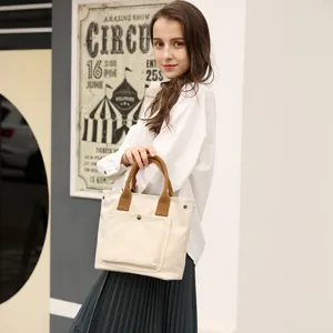 Women canvas tote bag casual handbag daily shoulder bag with brown handles and front pocket.