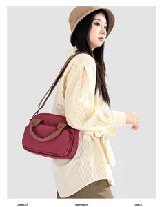 Detail view of casual canvas crossbody bag, featuring contrast color handles and straps.
