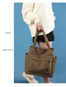 Canvas tote bag detail showing large capacity, brown fabric and front pocket design.
