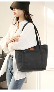 Detail view of the black canvas tote bag, featuring durable fabric and spacious capacity.