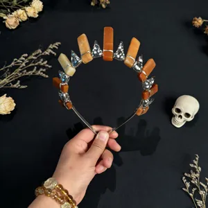 Detailed view of the crystal sun crown headband featuring orange stones and skull charms.