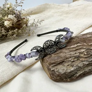 Vue détaillée d'un serre-tête en cristal fait main avec pendentif triple lune et pierres violettes.