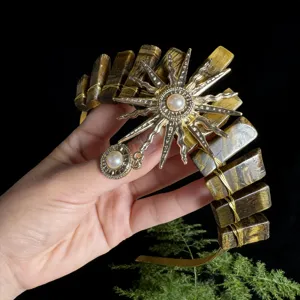 Detailed view of the tiger eye crystal crown headband with gold sun goddess pearl charm.