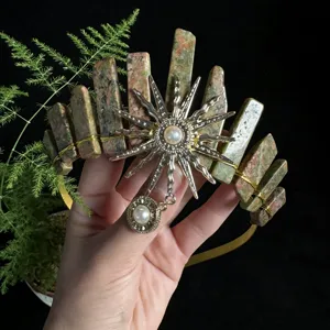Detail view of handmade crystal crown headband with sun goddess charm and natural stone pillars.