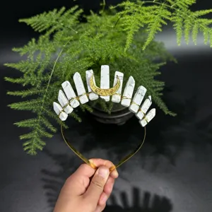 Detailansicht des Kristall Tiara Haarreifs mit weißen Steinsäulen und goldenem Mond Anhänger.
