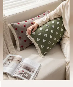 Detailed close-up of vintage long lumbar pillow featuring decorative tassels and embroidery.