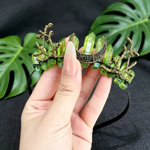 Detail view of the elegant green crystal crescent moon branch crown hair accessory for women.