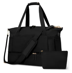 Detail view of black travel duffel bag showing gold zippers, USB port, and matching pouch.