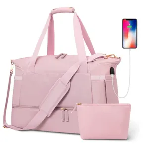 Detail view of the pink travel duffel bag showing USB charging port and zipper compartment.