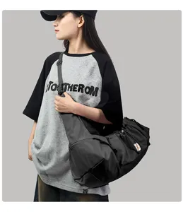 Detailed shot of casual black large capacity crossbody shoulder bag worn by model.