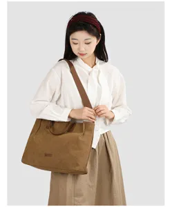 Detailed shot of the large capacity canvas tote bag worn by a model, showing texture and strap.