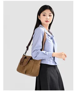 Canvas shoulder bag detail showing brown fabric texture, front pocket and sturdy strap.