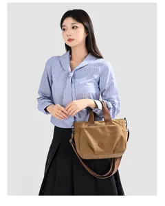Casual canvas shoulder bag for women, stylish brown handbag with top handles and strap.