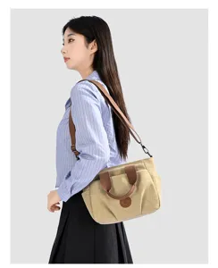Canvas shoulder bag detail shot, casual khaki tote with brown strap and daily use design.