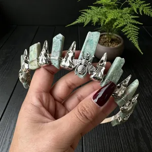 Gothic crystal crown detail featuring green stones, silver bird skulls, and a bee charm.