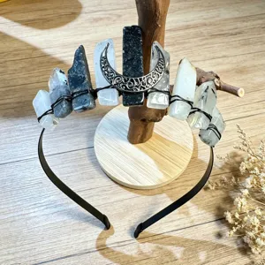 Crystal crown headband detail showing raw stones and metal moon charm on black band.