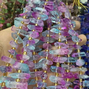 Primo piano perle cristallo irregolari colorate, componenti fai-da-te in fluorite con dettagli oro.