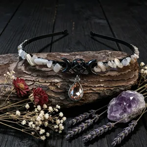 Detailed close up of crystal chip headband with metal pentagram and crescent moon charm on wood.