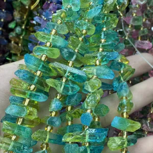 Primo piano dettagliato di perle di fluorite colorate irregolari con distanziatori dorati.