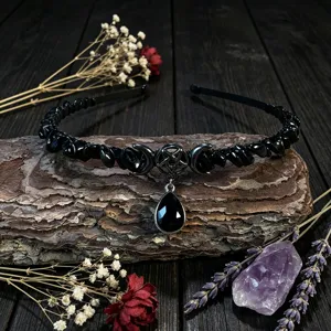 Detailed view of a gothic black crystal chip headband featuring moon and pentagram charms.