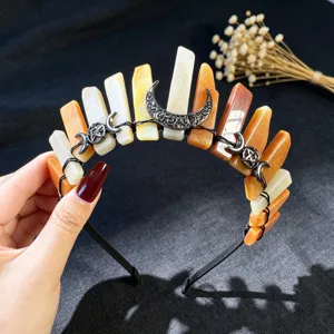 Detalle de la tiara de cristales en bruto con alfileres negros y colgante decorativo de luna gótica.