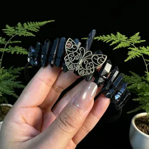 Detailed view of black crystal tiara with vintage bronze butterfly, gothic hair piece.