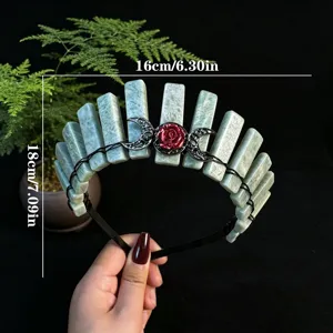 Detail view of handmade green crystal crown headband featuring a red rose and metal moon charms.