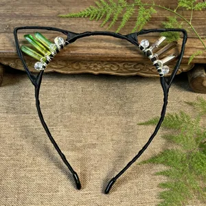 Close-up detail of handmade crystal cat ear headband with green and brown crystal sprouts.
