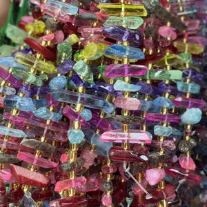Primo piano dettagliato di fili di perle di cristallo irregolari colorate con distanziatori.