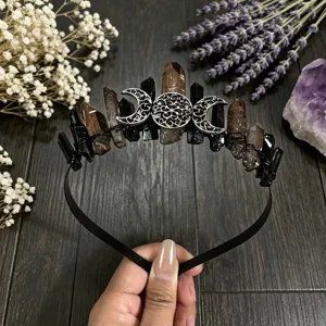 Detalle de corona de cristal natural con cuarzo negro y accesorios de luna plateados.