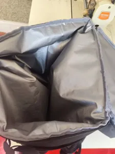 Detailed interior view of thermal cooler backpack with silver leakproof insulated lining.