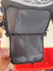 Detail view of insulated cooler backpack interior compartment, black waterproof oxford fabric.