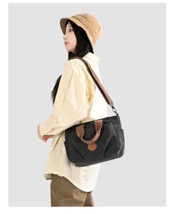 Stylish dark gray canvas shoulder bag worn by model, large capacity casual tote for women.