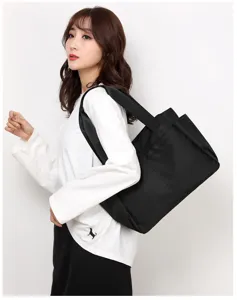 Detail shot of the black nylon shoulder bag, showing durable multi-pocket design and wide strap.