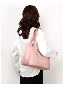 Casual pink nylon tote bag with multiple pockets, perfect for daily travel and large capacity.