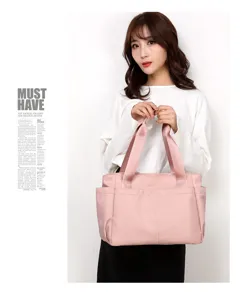 Pink nylon tote bag detail showing multi-pocket design, durable straps and large capacity.