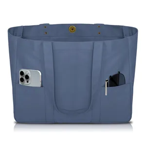 Blue canvas tote bag featuring exterior utility pockets and dual top handles detail.