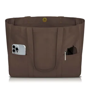 Close-up detail of the brown canvas tote bag showing exterior storage pockets and magnetic snap.