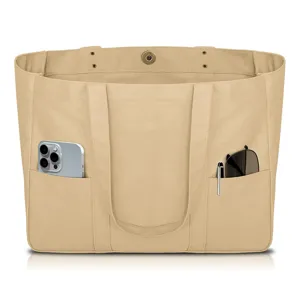 Canvas tote bag with multi-functional front pockets showing practical storage detail.