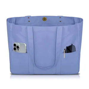 Blue canvas tote bag for women with multiple exterior pockets, casual shoulder handbag.