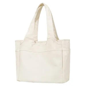 Canvas tote bag detail showing durable dual shoulder straps and convenient front pocket design.