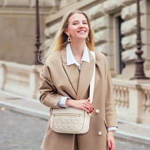 Detailed view of the quilted beige crossbody bag with adjustable strap and soft leather finish.