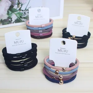 Detailed close-up of elastic nylon hair ties featuring small golden bead decorations, multi-color.