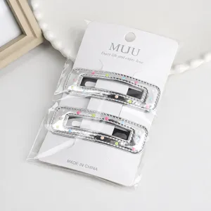 Detailed view of silver PU leather hair clips with colorful dots on card packaging.