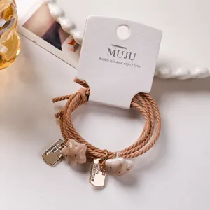 Brown multi-strand hair ties set of 2 with star charms and paper card packaging for women.